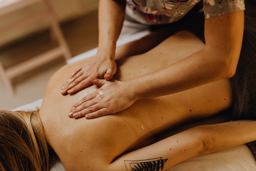 Close-up of a relaxing back massage at a spa with hands applying massage oil.